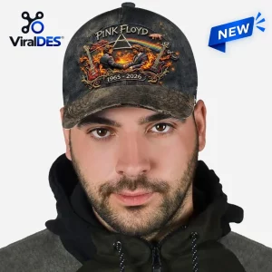 Front view of a man wearing a dark distressed cap featuring a graphic print with guitars and text.