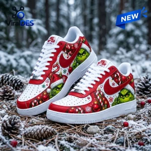 Side view of Grinch Christmas Red Nike Air Force 1 Sneakers resting on snowy ground with pinecones.