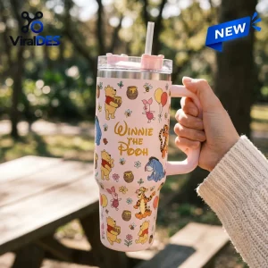 Winnie the Pooh Pink 40oz Tumbler with a handle, straw, and cartoon character pattern against a blurred forest background.