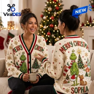 Two women wearing cream holiday cardigans with festive green character graphics and Merry Christmas text in a living room.