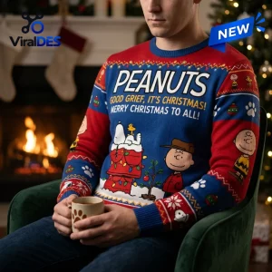 Front view of a person wearing a Peanuts Snoopy Christmas ugly sweater while holding a mug.