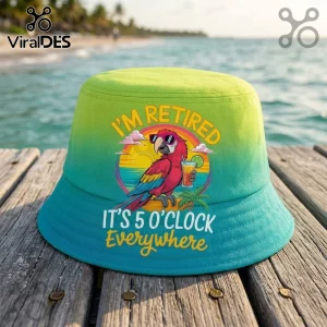 Retired Parrot I Am Retired Ombre bucket hat featuring a macaw with sunglasses, a drink, and tropical sunset on teal fabric.