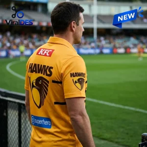 Hawthorn Football Club Gold Polo Shirt worn by a man at a stadium with team logo and corporate branding on the back.