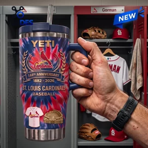 Hand holding a St. Louis Cardinals 144th Anniversary YETI tumbler with tie-dye pattern in a baseball locker room setting.