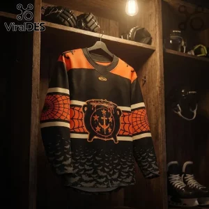 Norfolk Admirals 2026 Halloween Orange Black Hockey Jersey with cauldron graphic and bat patterns on a wooden hanger.