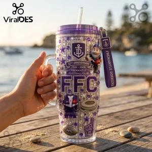 Fremantle Dockers 32nd Anniversary 40oz Tumbler with purple rhinestones, team logo, mascot, and straw on a wooden dock.