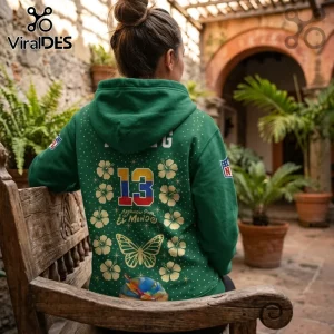 Karol G x Philadelphia Eagles Tropitour green hoodie featuring number 13, gold hibiscus flowers, and butterfly graphics.