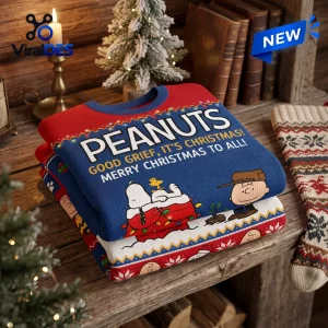 Folded blue and red Peanuts Snoopy Christmas ugly sweater on a wooden table.
