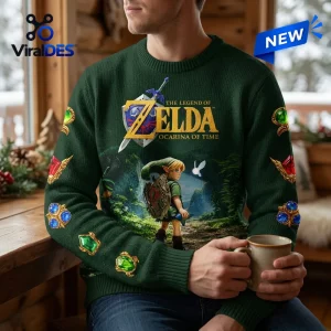 Front view of a person wearing a green knit sweater featuring a video game theme with gems printed on the sleeves.
