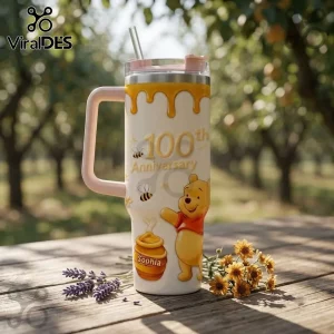 Winnie the Pooh 100th Anniversary Honey Pot 40oz Tumbler with honey drip design, bees, and personalized name on a wood table.