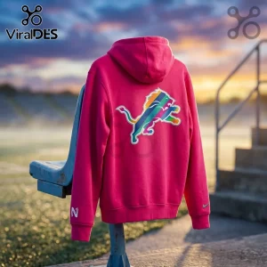 Detroit Lions 2026 Crucial Catch Pink Hoodie featuring a rainbow-striped team logo on the back, draped over a stadium seat.