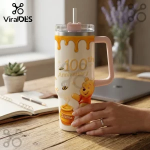Winnie the Pooh 100th Anniversary Honey Pot 40oz Tumbler with honey drip design, bees, and personalized name on a wood desk.