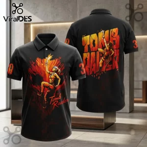 Tomb Raider 30th Anniversary black polo shirt with Lara Croft graphic, orange fire accents, and number 30 on the sleeve.
