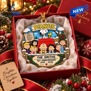 Peanuts 76th Anniversary Christmas ornament featuring Snoopy and the gang on a red doghouse inside a gift box.