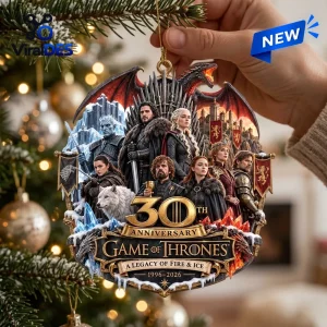 Hand holding a Game of Thrones 30th Anniversary Christmas ornament featuring character illustrations and a golden logo.