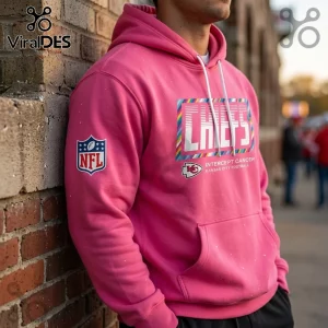 Kansas City Chiefs Crucial Catch Pink Pullover Hoodie with white drawstrings and NFL branding leaning against brick wall.