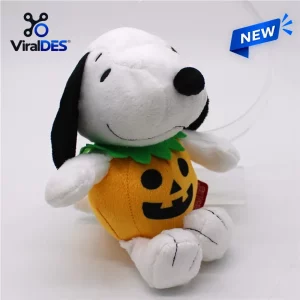 Front view of a white dog plush toy sitting inside a bright orange carved pumpkin costume.