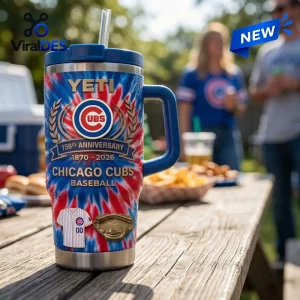 Front view of a Chicago Cubs 156th Anniversary Stanley Tumbler with red and blue tie-dye pattern on a wooden picnic table.