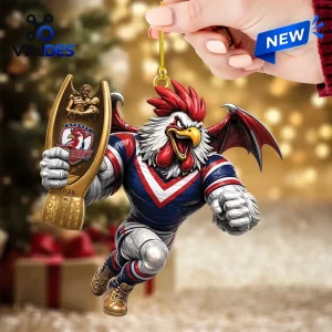 Closeup of Sydney Roosters 2026 Premiers Christmas Ornament held against a blurred tree.
