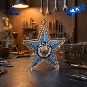 Front view of a blue star-shaped Manchester City ornament featuring gold stars on a workshop workbench.