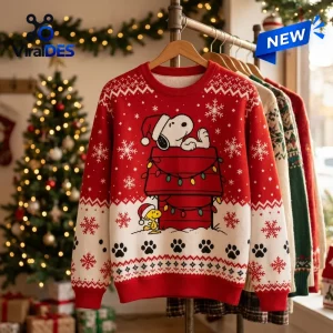 Front view of a red Peanuts Snoopy Holiday Ugly Sweater featuring Snoopy on a doghouse with snowflakes.