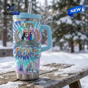 Front view of a blue tumbler with character graphics and text on a snow-covered wooden table.