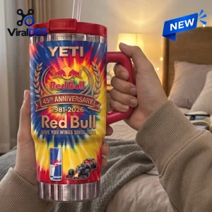 Hand holding a Red Bull 45th Anniversary YETI handle tumbler with a colorful tie-dye and flame pattern.