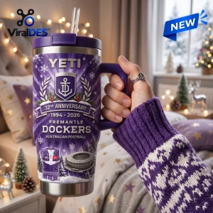 Hand holding purple Fremantle Dockers 32nd Anniversary YETI Tumbler with winter holiday design.