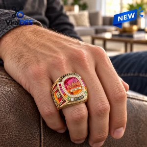 Closeup of a gold Def Leppard 2027 Tour Championship Ring worn on a hand.