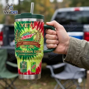 Hand holding a Mountain Dew 86th Anniversary Tumbler Cup featuring red and green tie-dye graphics and a straw lid.