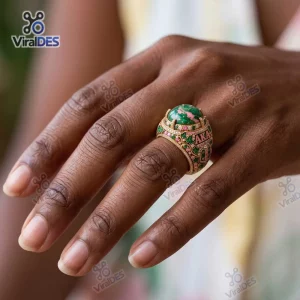 Closeup of an Alpha Kappa AKA Gold Ring with a large green stone worn on a finger.