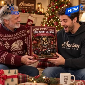 Two men holding the Indian Motorcycle 125th Anniversary 2026 Advent Calendar in a festive room with a Christmas tree.