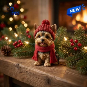 Front view of a Yorkshire Terrier figurine wearing a red knitted winter hat and scarf.
