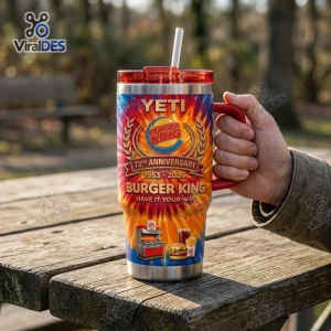 Hand holding Burger King 73rd Anniversary Handle Tumbler Cup with flame graphic on a wooden table.