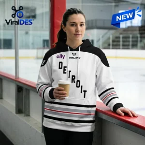 Front view of a person wearing the PWHL Detroit 2026 Away Hoodie at an ice rink.