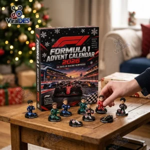 Front view of the Formula One 2026 Advent Calendar box alongside miniature driver figurines on a wooden table.