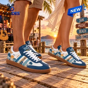Lifestyle view of Kenny Chesney Blue Samba Sneakers worn on a wooden boardwalk near a tropical beach at sunset.
