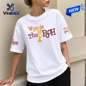 Front view of a white t-shirt featuring multicolor text and a yellow trumpet graphic.