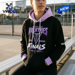 Front view of a person wearing a black and purple hoodie with Golden State Valkyries 2026 Finals graphics sitting on a bleacher.