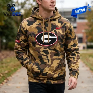 Front view of a person wearing a brown camo hoodie with a team logo.