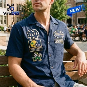 Front view of a man wearing a dark blue Notre Dame Fighting Irish Camp Hawaiian Shirt with patches.