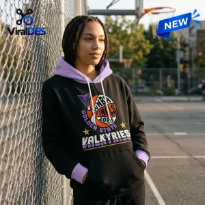 Front view of a person wearing the Golden State Valkyries 2026 WNBA Finals Pullover by a chain-link fence.