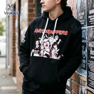 Front view of Amyl and the Sniffers Australia Tour Hoodie on a person standing near a poster-covered brick wall.