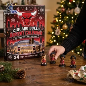 Hand holding a figurine next to the Chicago Bulls Mini Figurine Advent Calendar 2026 on a wooden surface.