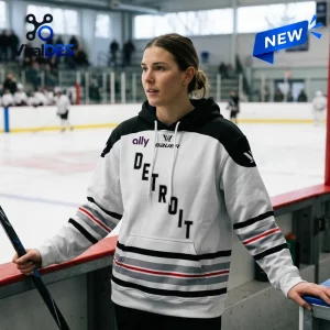 Front view of a person wearing the PWHL Detroit 2026 Away Hoodie at an indoor ice hockey rink.