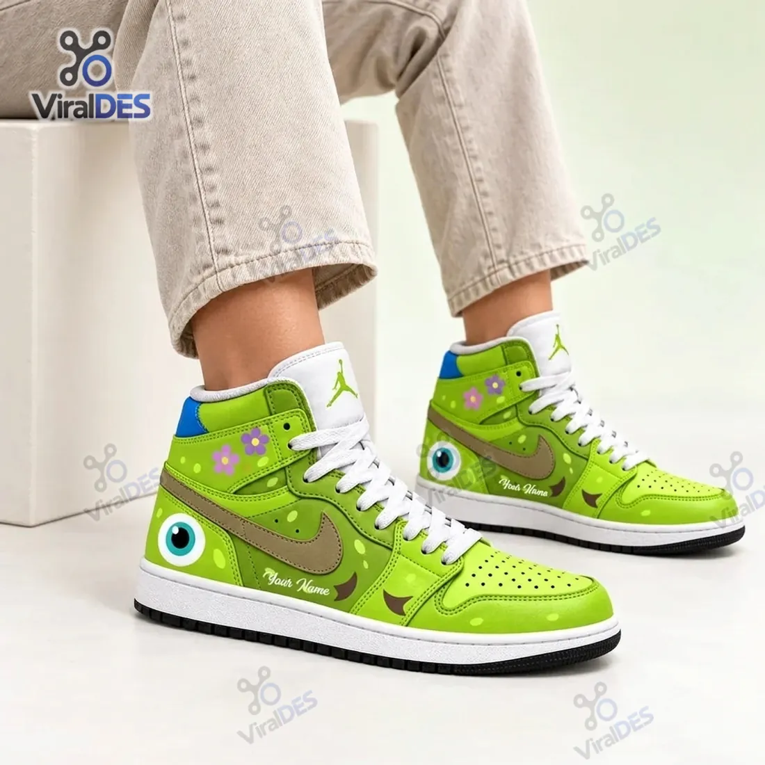 On-foot studio view of the Green Monster Eye Custom High Top Sneakers displaying the cyan heel eyeball, pink and purple collar flowers, and white tongue