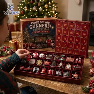 Close-up of a person holding an ornament from the Arsenal Christmas Advent Calendar 2026 set filled with festive items.