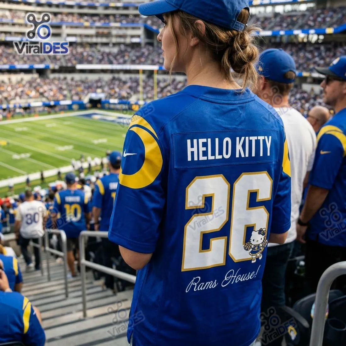Rear stadium view of the Hello Kitty x Los Angeles Rams Blue Football Jersey showing HELLO KITTY nameplate, number 26 with cheerleader graphic, and Rams House! script