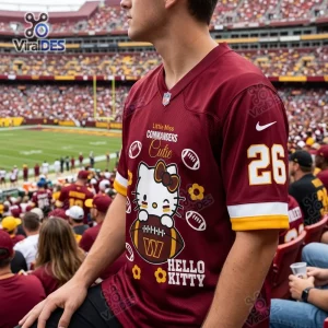 Side angle of a person wearing a burgundy football jersey with cartoon cat graphics and text at a stadium.