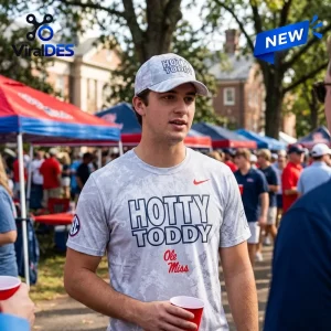 Man wearing an Ole Miss Rebels Hotty Toddy grey shirt and matching cap outdoors at a tailgate.